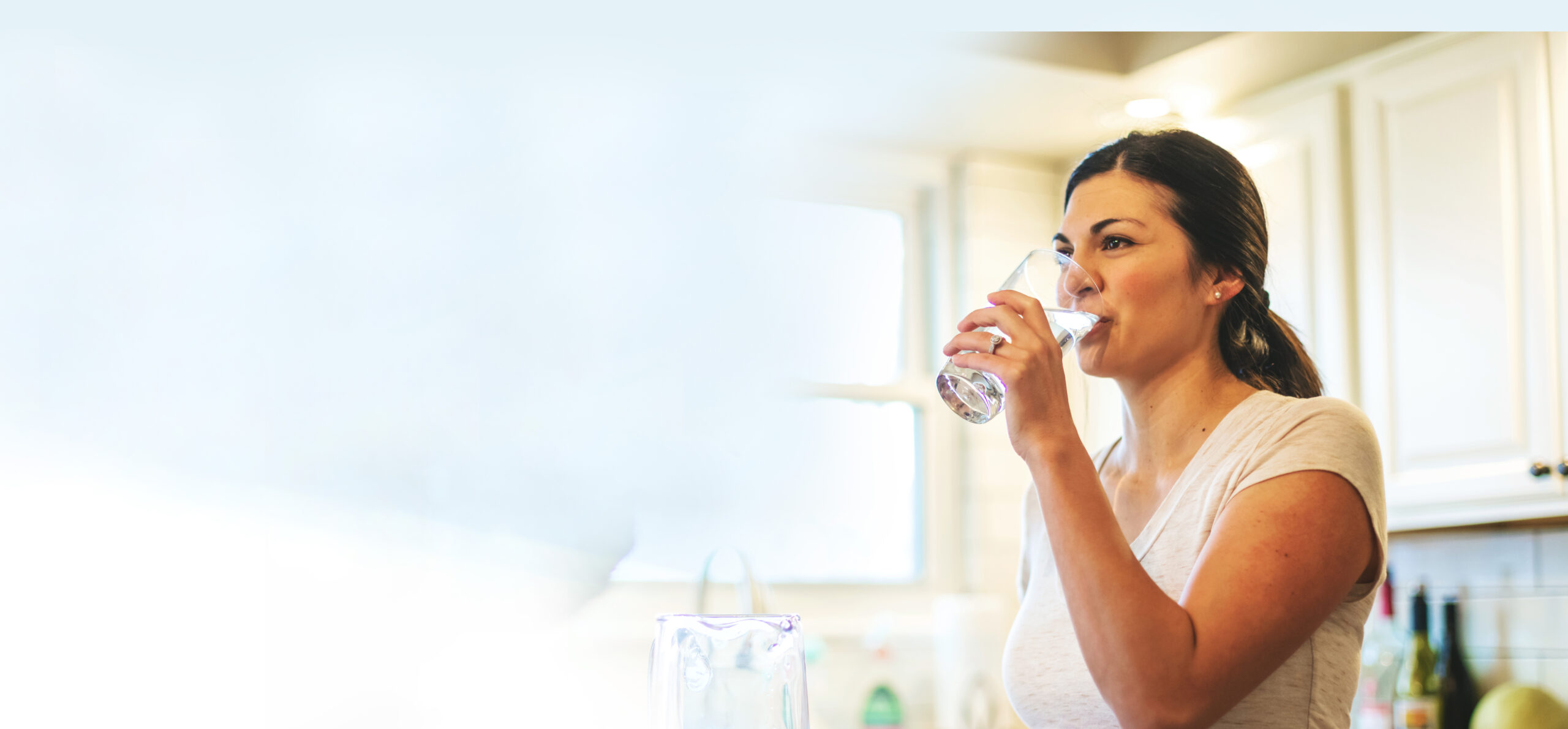 Woman drinking water in kitchen